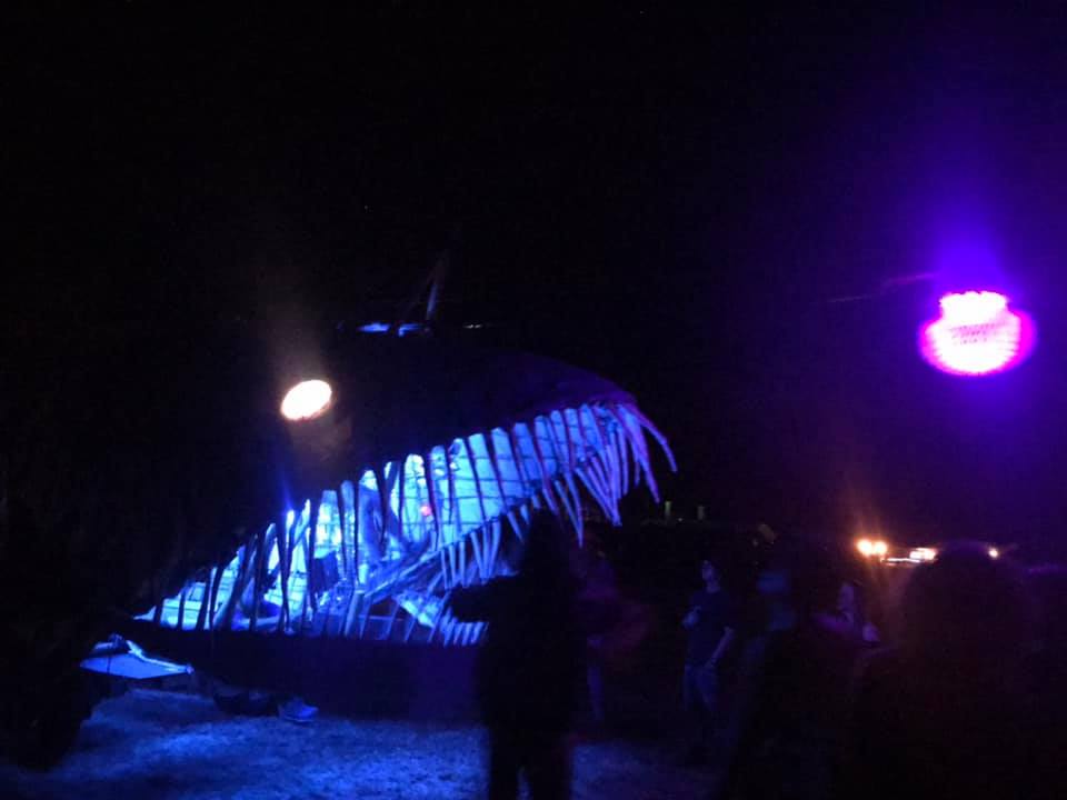 Mobile Art car that looks like a giant Angler Fish, glowing at night.