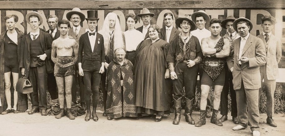A black and white photograph of a group of old fashioned circus performers
