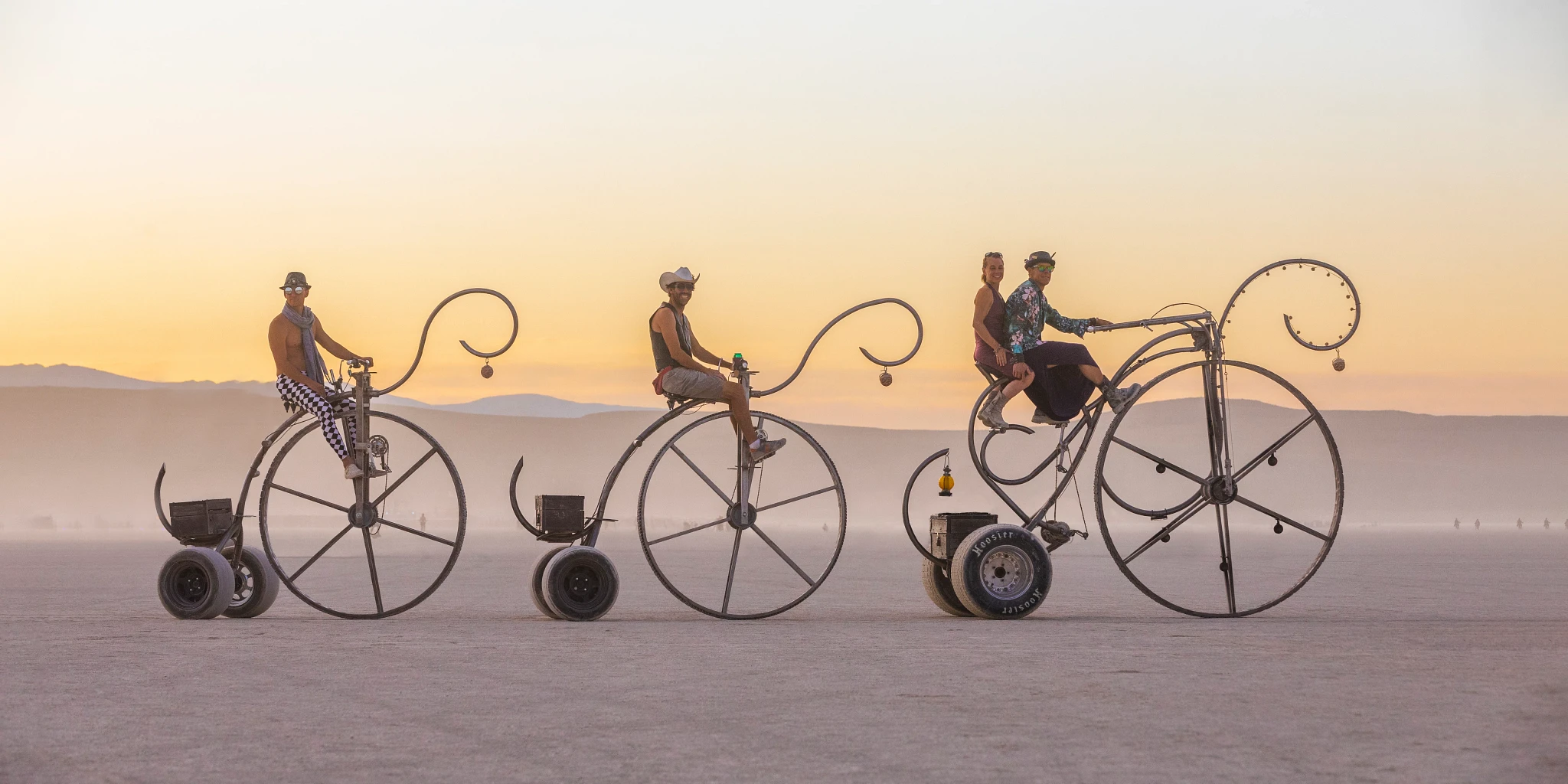 3 mutant bikes in penny farthing style against the backdrop of the Playa at sunset