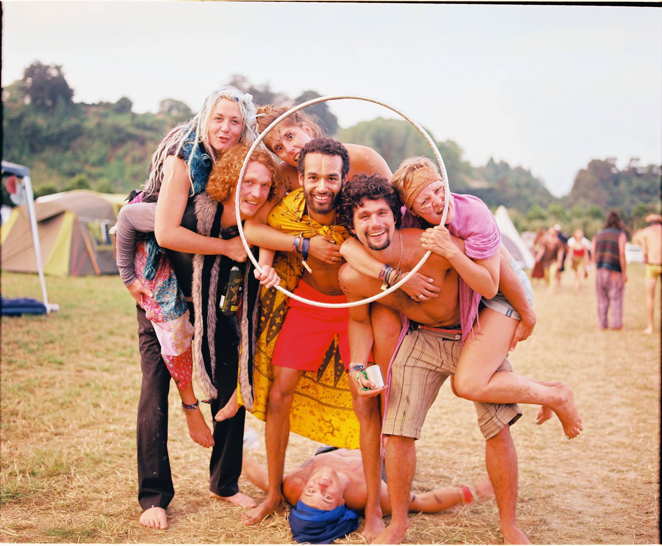 A group of 6 smiling people posing on the Paddock with a hula-hoop