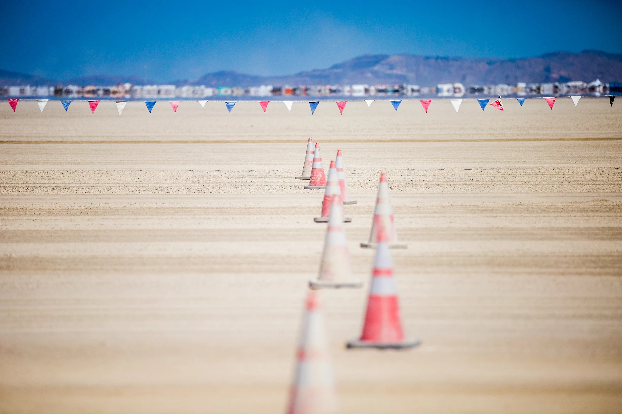 Orange traffic cones stand in contrast to the desert at the entrance to Black Rock City