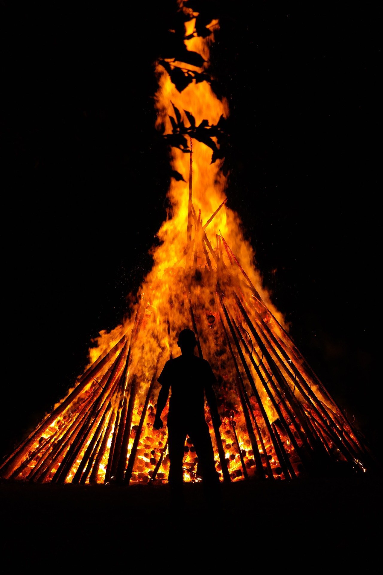 An image depicting a person in front of a bonfire.