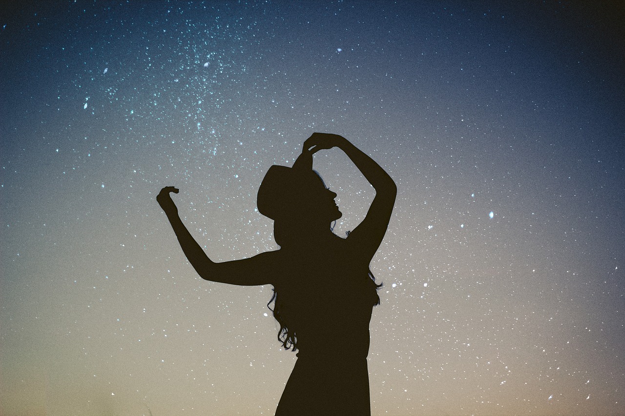 An image of a woman silhouetted against the night sky.
