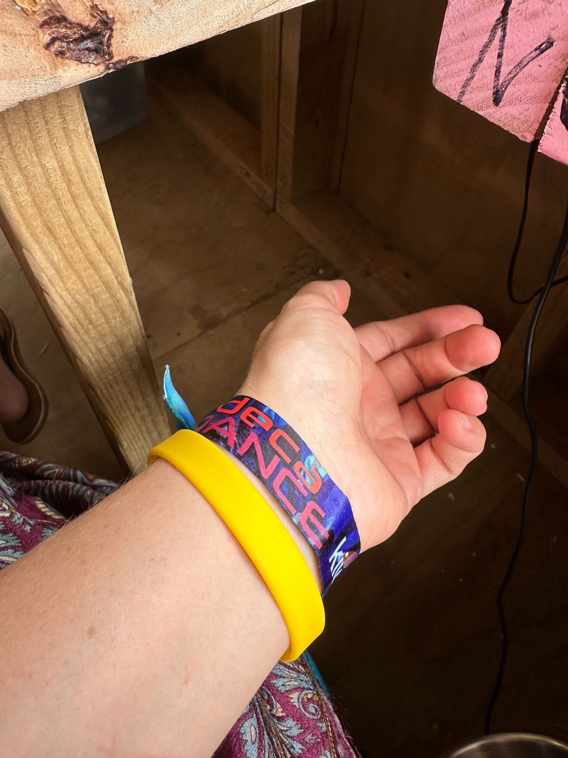 A yellow photography consent wristband.
