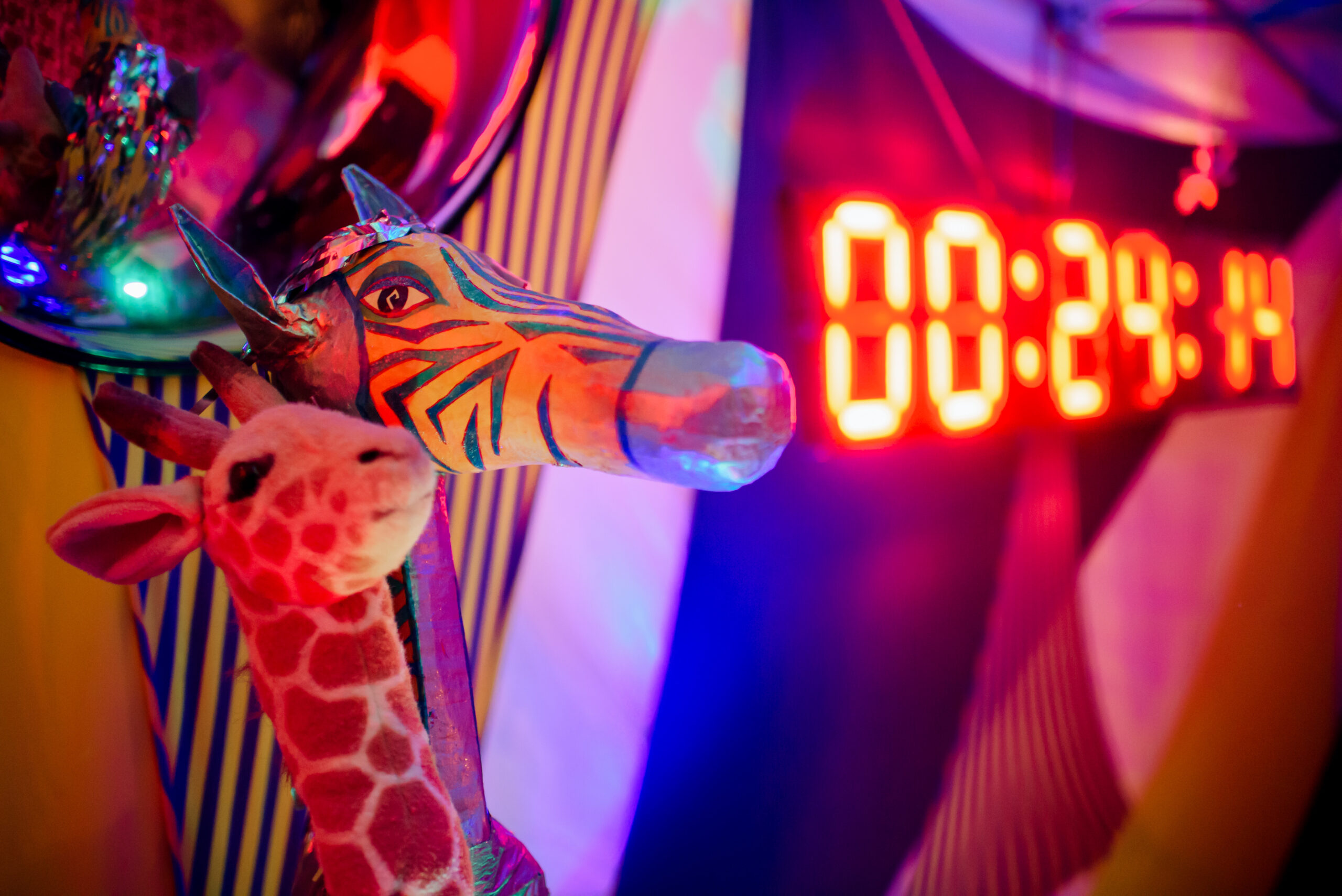 A wooden giraffe sits in front of a glowing orange timer