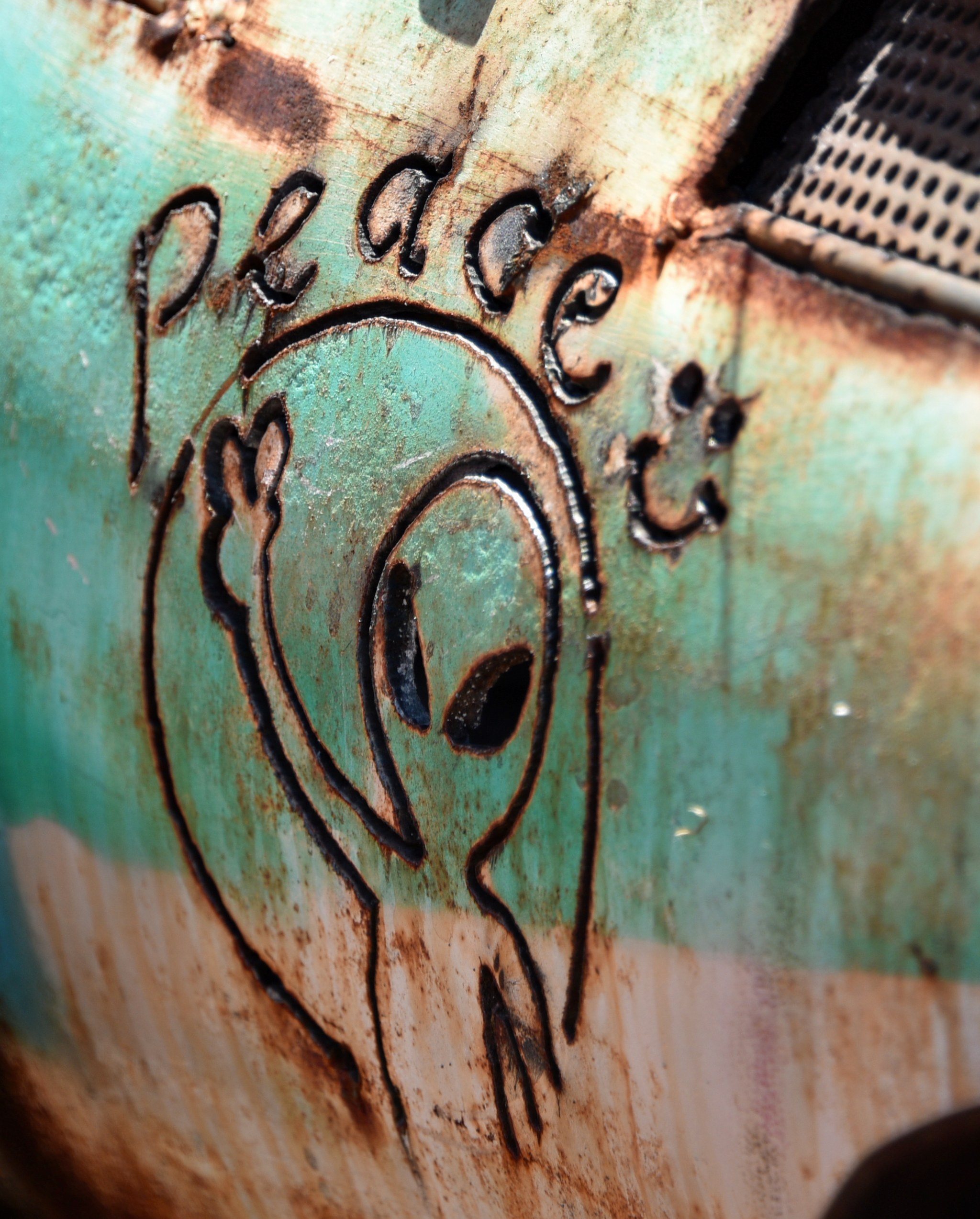An image of an alien and the word 'peace' on the side of some metal.