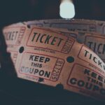 A spool of white and red tickets sits against a dark background