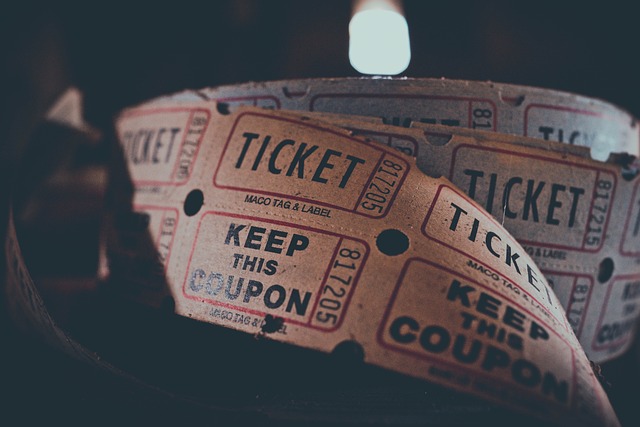 A spool of white and red tickets sits against a dark background