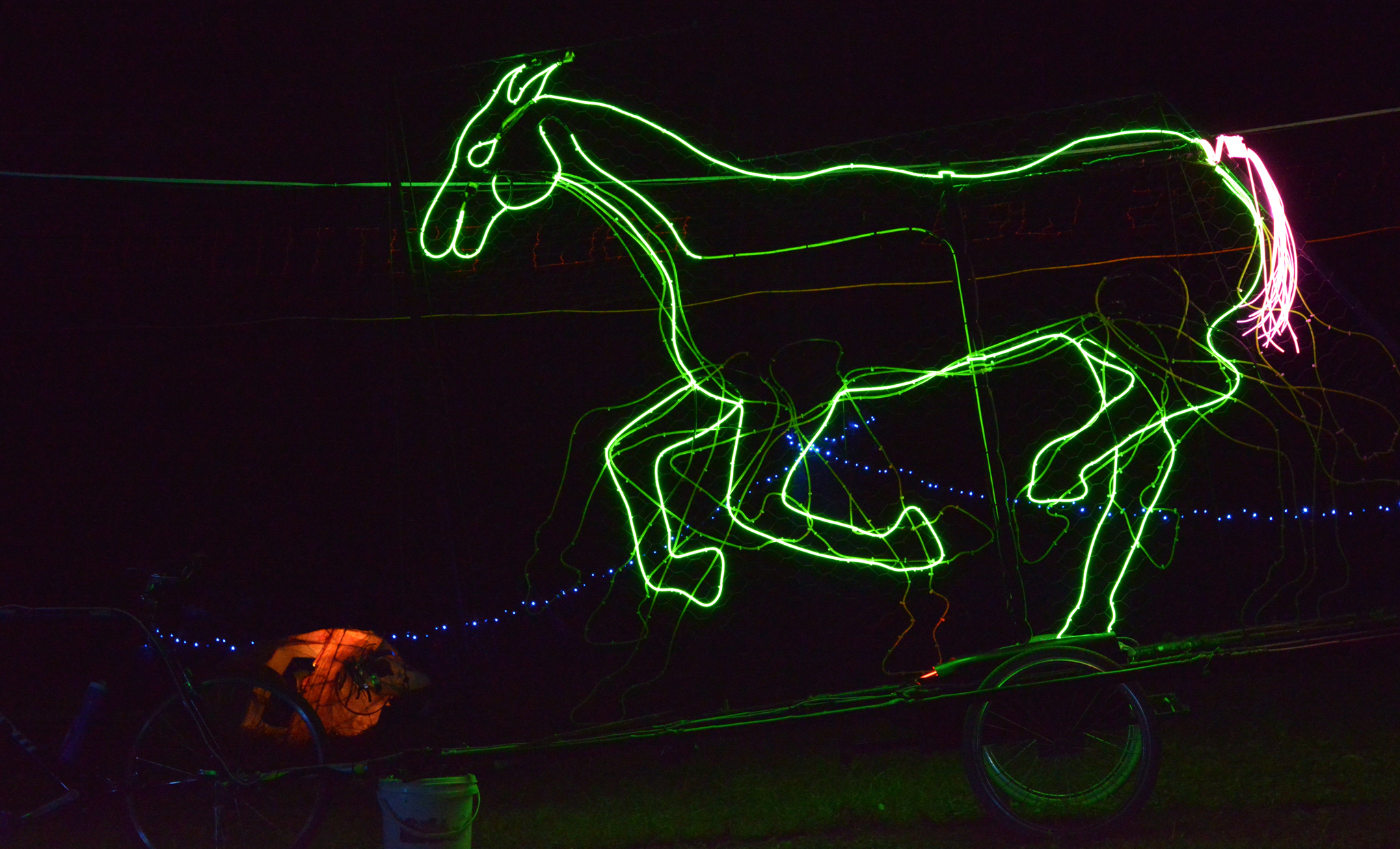 A bright green LED horse on a dark night