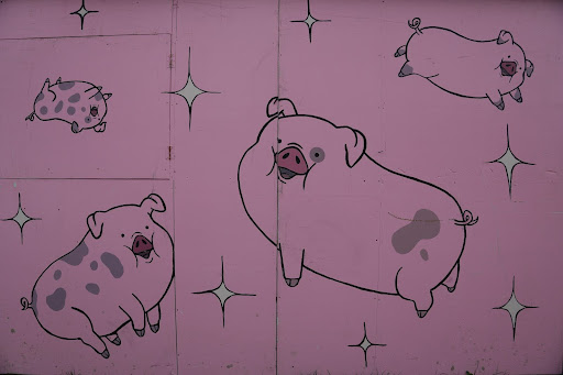 A pink wallpaper with chubby pigs and little stars on it