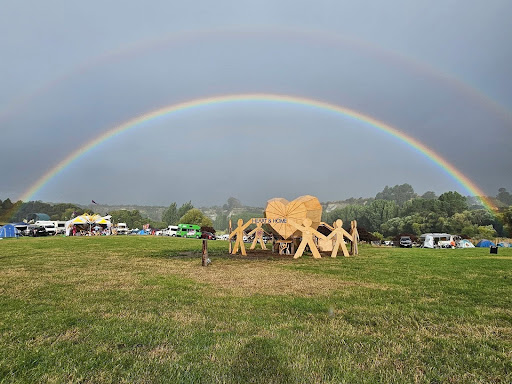 Taken by Heather Schafer the temple heart structure sits on the paddock with a grey sky background and a very bright rainbow