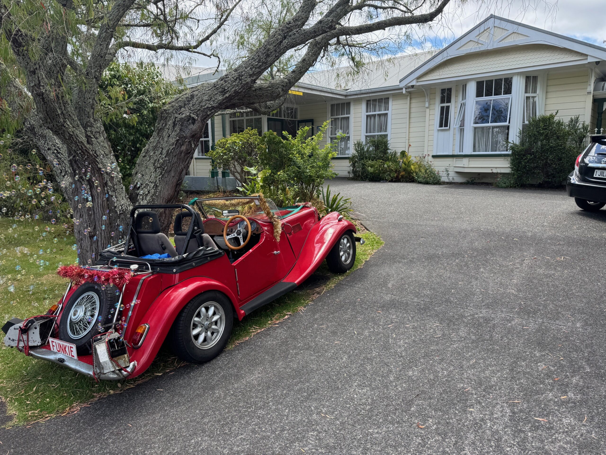 T-Car – David Gall A fancy red car parked on a driveway